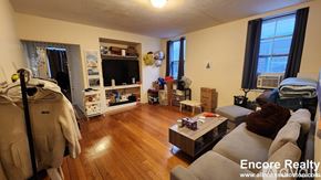 Boston apartment for rent - A living room with a couch, a chair, a coffee table, and a bookshelf.