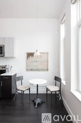 Milwaukee apartment for rent - A kitchen with a table and chairs and a painting hanging on the wall.