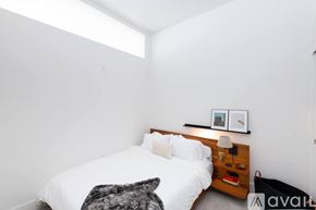 Milwaukee apartment for rent - A bedroom with a bed, nightstand, and a picture on the wall.