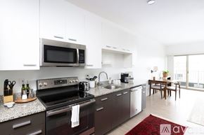 Milwaukee apartment for rent - A modern kitchen with a black stove top oven and microwave.