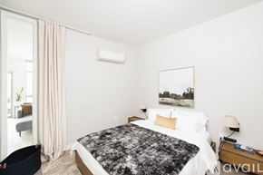 Milwaukee apartment for rent - A bedroom with a large bed and a painting on the wall.