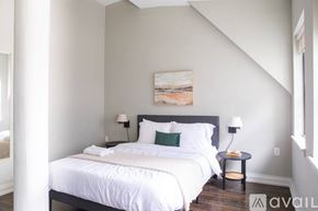 Milwaukee apartment for rent - A bedroom with a large bed and a painting on the wall.