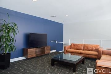 Milwaukee apartment for rent - A living room with a brown couch, a black coffee table, and a flat screen TV.