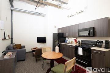 Milwaukee apartment for rent - A kitchen area with a table and chairs and a microwave on the counter.