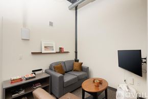 Milwaukee apartment for rent - A living room with a grey couch, a coffee table, and a television.