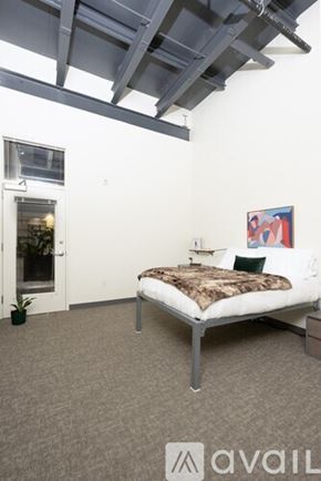Milwaukee apartment for rent - A bedroom with a bed, a small table, and a painting on the wall.