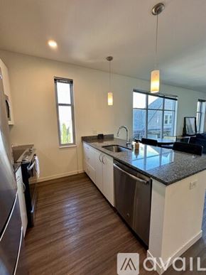 Milwaukee apartment for rent - A kitchen with white cabinets and a black countertop.