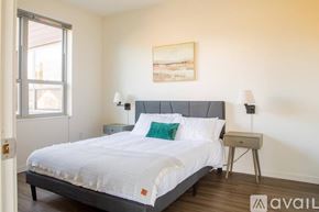 Milwaukee apartment for rent - A bedroom with a large bed, a nightstand, and a painting on the wall.