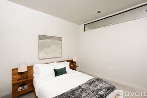Milwaukee apartment for rent - A bedroom with a bed, nightstand, and a painting on the wall.