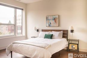 Milwaukee apartment for rent - A bedroom with a large bed and a painting on the wall.
