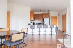 Milwaukee apartment for rent - A kitchen with a table and chairs in the foreground and a bar area in the background.