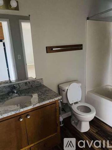 Greenville apartment for rent - A kitchen with a white refrigerator, brown cabinets, and a sink.