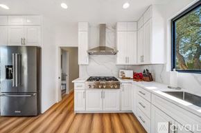 Palm Desert house for rent - A modern kitchen with white cabinets and a wooden floor.