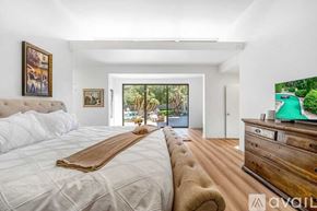 Palm Desert house for rent - A bedroom with a large bed and a wooden dresser.