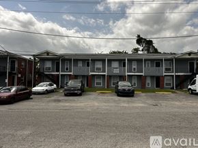 Kenner apartment for rent - A parking lot with several cars and a building in the background.