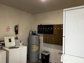 Kenner apartment for rent - A laundry room with a washing machine, dryer, and a water heater.