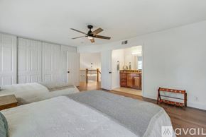Huntington Beach house for rent - A bedroom with a large bed and a ceiling fan.