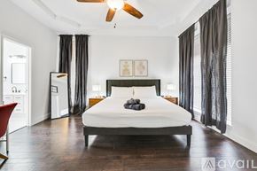 Waxahachie apartment for rent - A bedroom with a large bed and a ceiling fan.
