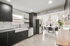 Waxahachie apartment for rent - A modern kitchen with black cabinets and a dining table.