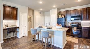 Frisco apartment for rent - A kitchen with a white island and dark wood cabinets.