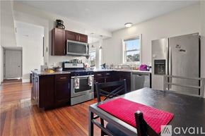 Providence apartment for rent - A kitchen with dark wood cabinets and a red mat on the table.