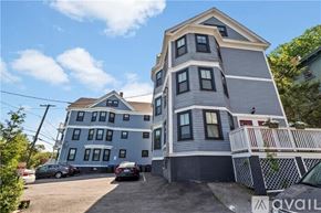 Providence apartment for rent - A two-story house with a grey exterior and a white picket fence.