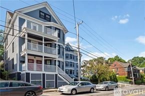 Providence apartment for rent - A two-story building with a balcony and a car parked in front.