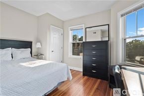 Providence apartment for rent - A bedroom with a large bed and a black dresser.