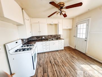 Lubbock house for rent - A kitchen with a white stove and cabinets.
