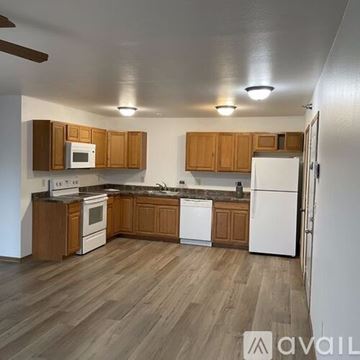Galesville apartment for rent - A kitchen with wooden cabinets and white appliances.