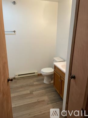 Galesville apartment for rent - A bathroom with a toilet, sink, and wooden floors.