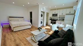 Tarzana house for rent - A modern bedroom with a large bed and a kitchen area in the background.