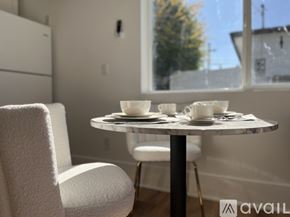 Tarzana house for rent - A table with two cups and saucers on it sits in front of a window.