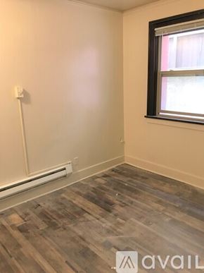 Seattle apartment for rent - A room with a window and a wooden floor.