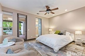 La Quinta house for rent - A bedroom with a large bed and a ceiling fan.
