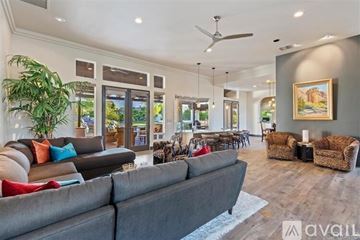 La Quinta house for rent - A spacious living room with a grey sofa and a ceiling fan.