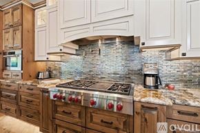 La Quinta house for rent - A kitchen with a stone backsplash and a stove top oven.