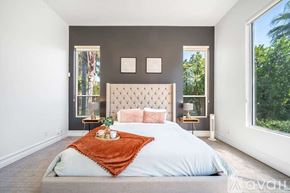 La Quinta house for rent - A bedroom with a large bed and a window overlooking trees.