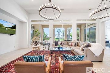 La Quinta house for rent - A living room with a large rug and a TV on the wall.