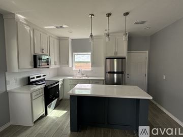 Weslaco house for rent - A modern kitchen with a large island in the center.