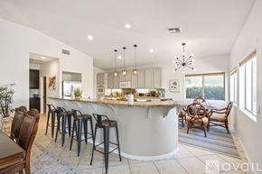 Indio house for rent - A modern kitchen with a bar area and a dining table set up.