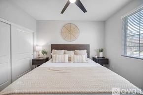 La Quinta house for rent - A bedroom with a large bed and a ceiling fan.