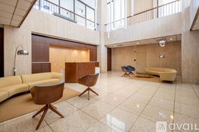 Washington apartment for rent - A spacious living room with a yellow sofa, wooden chairs, and a white bathtub.