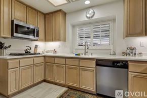 La Quinta house for rent - A kitchen with wooden cabinets and a stainless steel dishwasher.