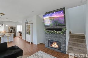 San Diego townhouse for rent - A modern living room with a fireplace and a flat screen TV mounted above it.