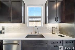 La Quinta house for rent - A modern kitchen with dark brown cabinets and a stainless steel refrigerator.