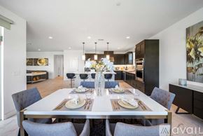 La Quinta house for rent - A modern dining room with a long table set for a meal.