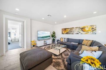 La Quinta house for rent - A living room with a grey couch, a coffee table, and a painting on the wall.