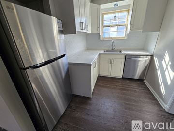 Ypsilanti house for rent - A kitchen with a stainless steel refrigerator and wooden flooring.