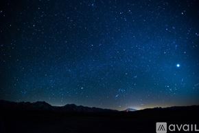 Tollhouse townhouse for rent - A starry night sky over a mountain range.